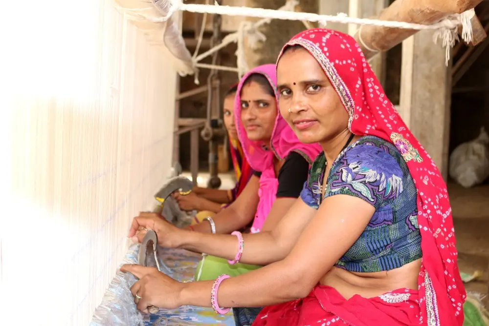 Jaipur carpet weaver artisan working at traditional loom tying knots - handmade rug workshop Karbala authentic craft demonstration
