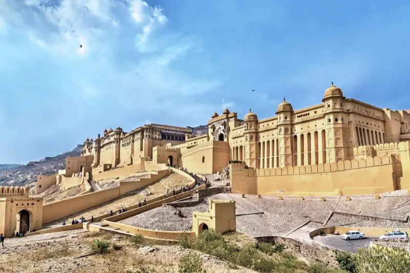 Amer Fort Jaipur aerial view at dawn — amber sandstone and white marble ramparts near handmade carpet showroom Karbala